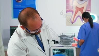 医生持有平板电脑下巴x射线显示病人
